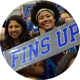 two female students holding a sign that reads fins up